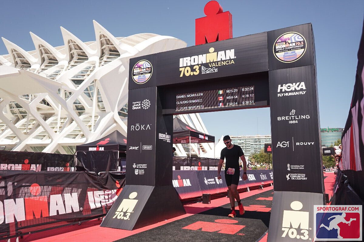 Dan finishing the Ironman 70.3 Valencia, walking under the finish arch