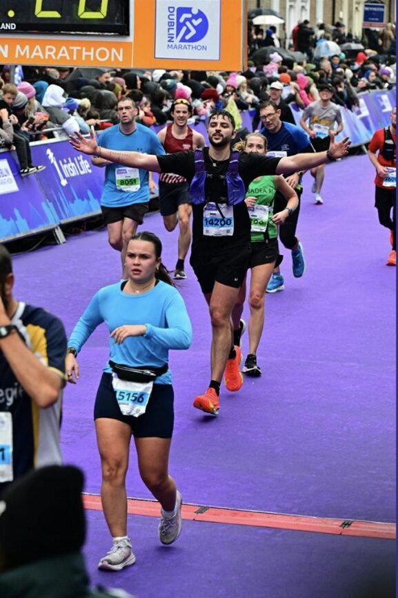 Dan with arms raised crossing the Dublin Marathon finish line